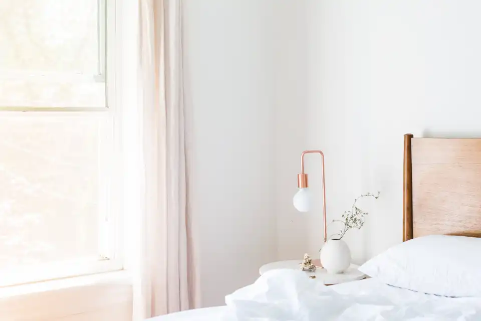 Quarto claro com cama de casal, cortina leve e luz natural